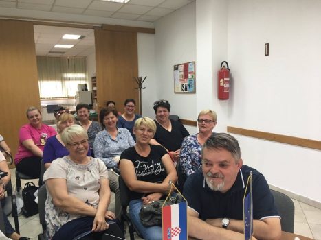 Radni sastanak projektnog tima i djelatnica na projektu „Želim živjeti bolje“ – Zaželi. Na fotografiji je vidljiva skupina žena i jedan muškarac koji sjede u prostoru Udruge slijepih.