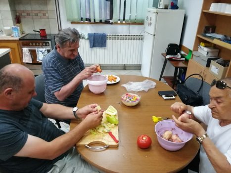Sport,rekreacija i kulinarska radionica.Na fotografiji tri muške osobe čiste povrće u sklopu kulinarske radionice
