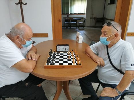 Na fotografiji dva muškarca igraju šah.
