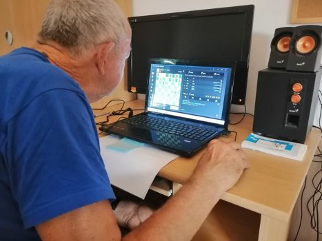 Na fotografiji muškarac radi na računalu.