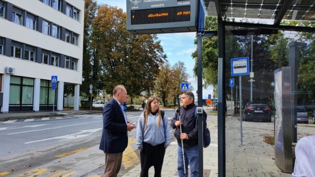 Na fotografiji predsjednik i djelatnica Udruge slijepih preuzimaju uređaje za zvučnu najavu autobusnih linija gradskog prijevoza.