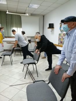 Na fotografiji skupina ljudi vježba vježbe za razgibavanje.