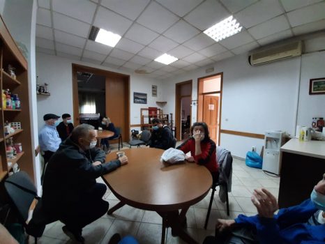 Na fotografiji skupina ljudi sjedi i razgovara.