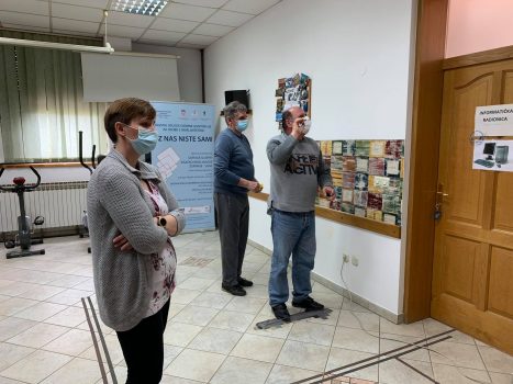Na fotografiji se nalaze dvije muške i jedna ženska osoba, dvije muške osobe igraju govorni pikado.