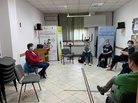 Na fotografiji četiri ženske i jedna muška osoba sjede u polukrugu na radionici psihosocijalne podrške.