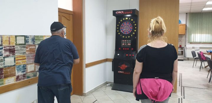 Na fotografiji se nalaze muška i ženska osoba koji igraju govorni pikado.