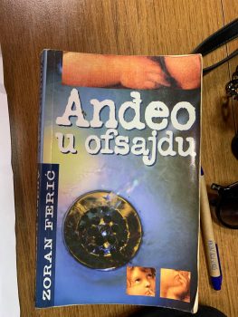 Na fotografiji se nalazi knjiga "Anđeo u ofsajdu" autora Zorana Ferića.
