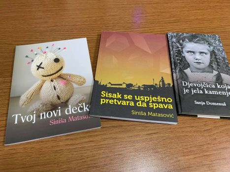Na fotografiji tri knjige, Tvoj novi dečko, Sisak se uspješno pretvara da spava Siniše Matasovića i knjiga Djevojčica koja je jela kamenje autorice Sanje Domenuš
