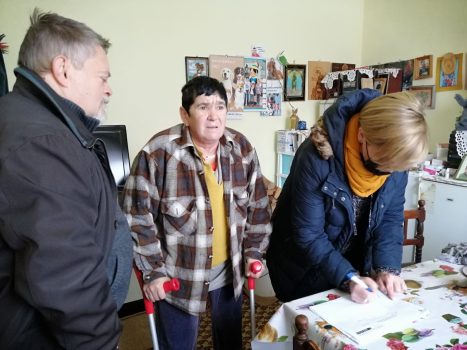 Na fotografiji se nalaza ženska i muška osoba u posjeti ženskoj osobi, koja se kreće na štakama.